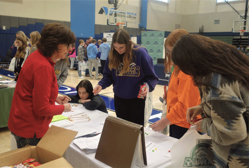 Elain Stone from Fulton County Farm Bureau helping students play Ag Careers Bingo