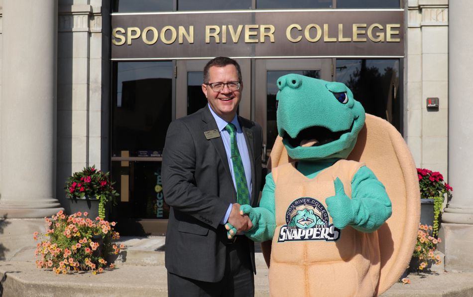 President Curt Oldfield shaking hands with SRC mascot, Sheldon (a turtle)