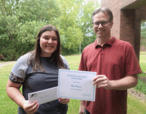 student receiving a scholarship award from teacher 