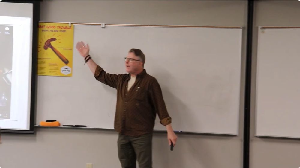 Doug Okey giving College Theme presentation on "Make Good Trouble"