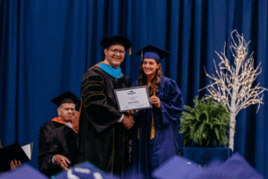 Image of Alyssa Zarello receiving the Pay It Forward Award from President Oldfield at the 63rd Commencement at Spoon River College