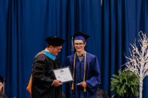 Image of Connor Taylor receiving a Student Achievement Award from President Oldfield at the 63rd Commencement at Spoon River College