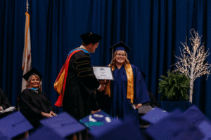Image of Traci Brown receiving the Pay It Forward award from President Oldfield at the 63rd Commencement at Spoon River College