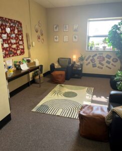 SRC Wellness Room Macomb campus--image of a cozy setting with lounge chairs, plants, and a resource table.