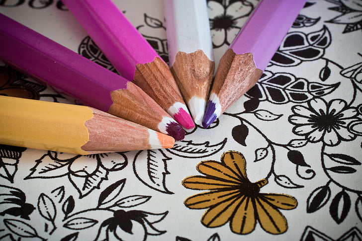 close up of colored pencils on a coloring book page