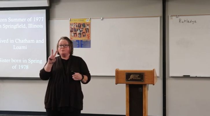 Amy Rutledge giving college theme presentation, "Brat, Biologist, Bearer (of child)"