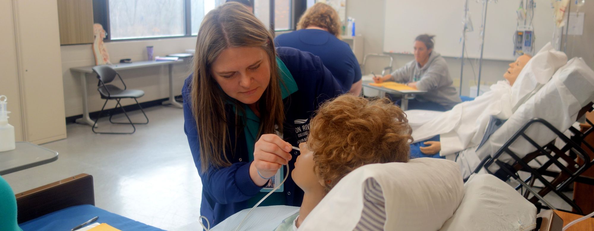 Nursing student performing procedure on patient mannequin