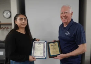 Image of outgoing student trustee Esmerelda "Esme" Uribe with Board Chair Jerry Cremer at the Board of Trustees Meeting