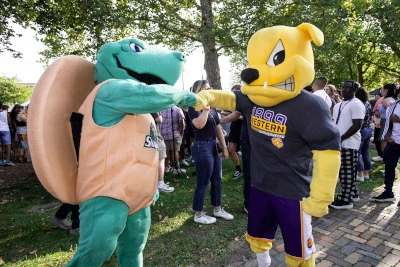 SRC Snappers mascot Sheldon giving a fist bump to WIU bulldog mascot